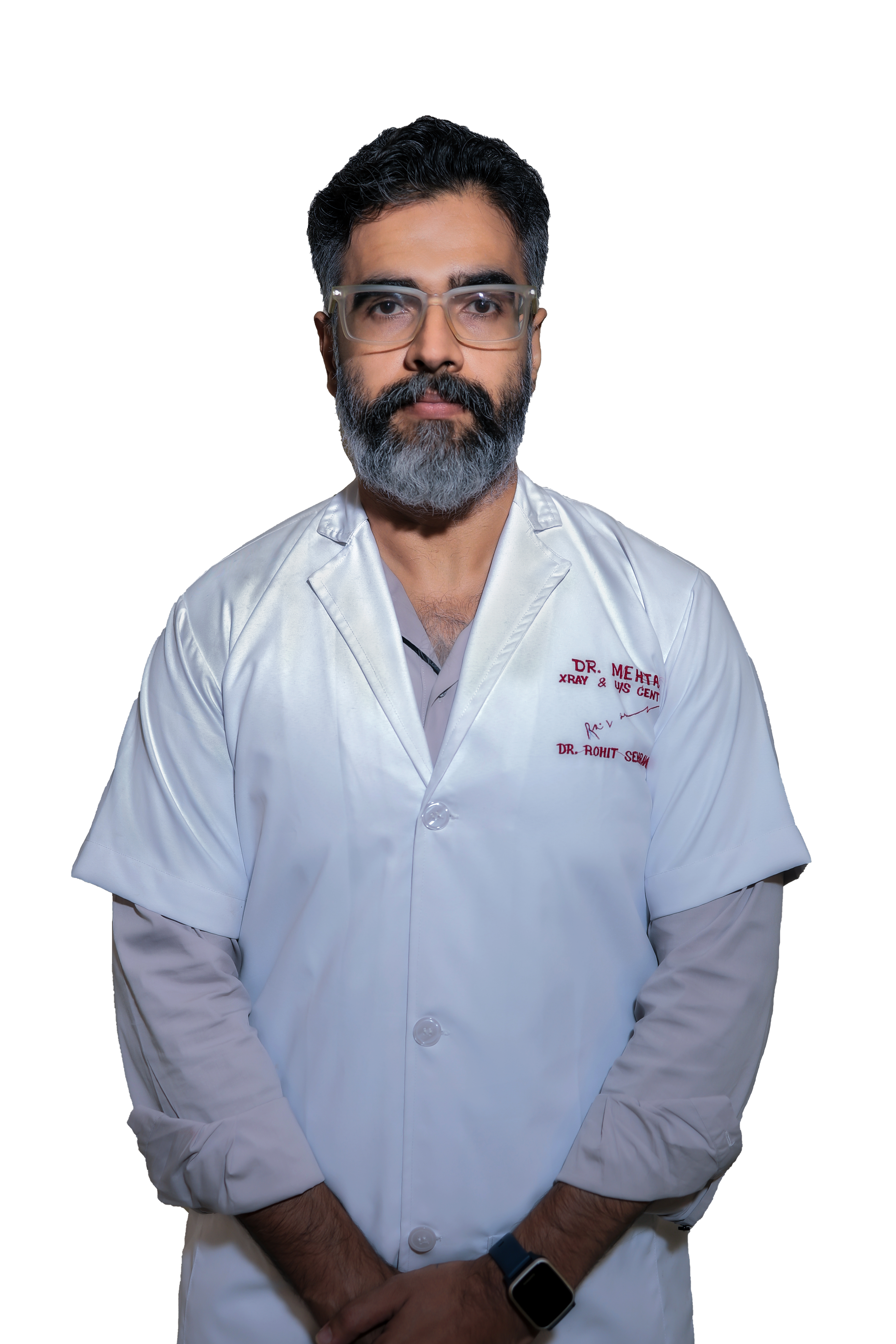 Technician operating the controls of a GE MRI machine with a patient inside.